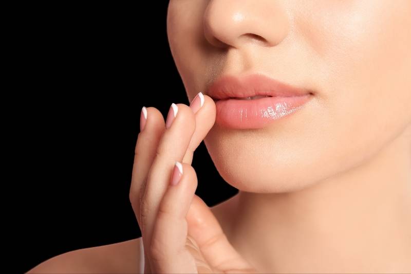 versa Lip woman touching lips with fingertips
